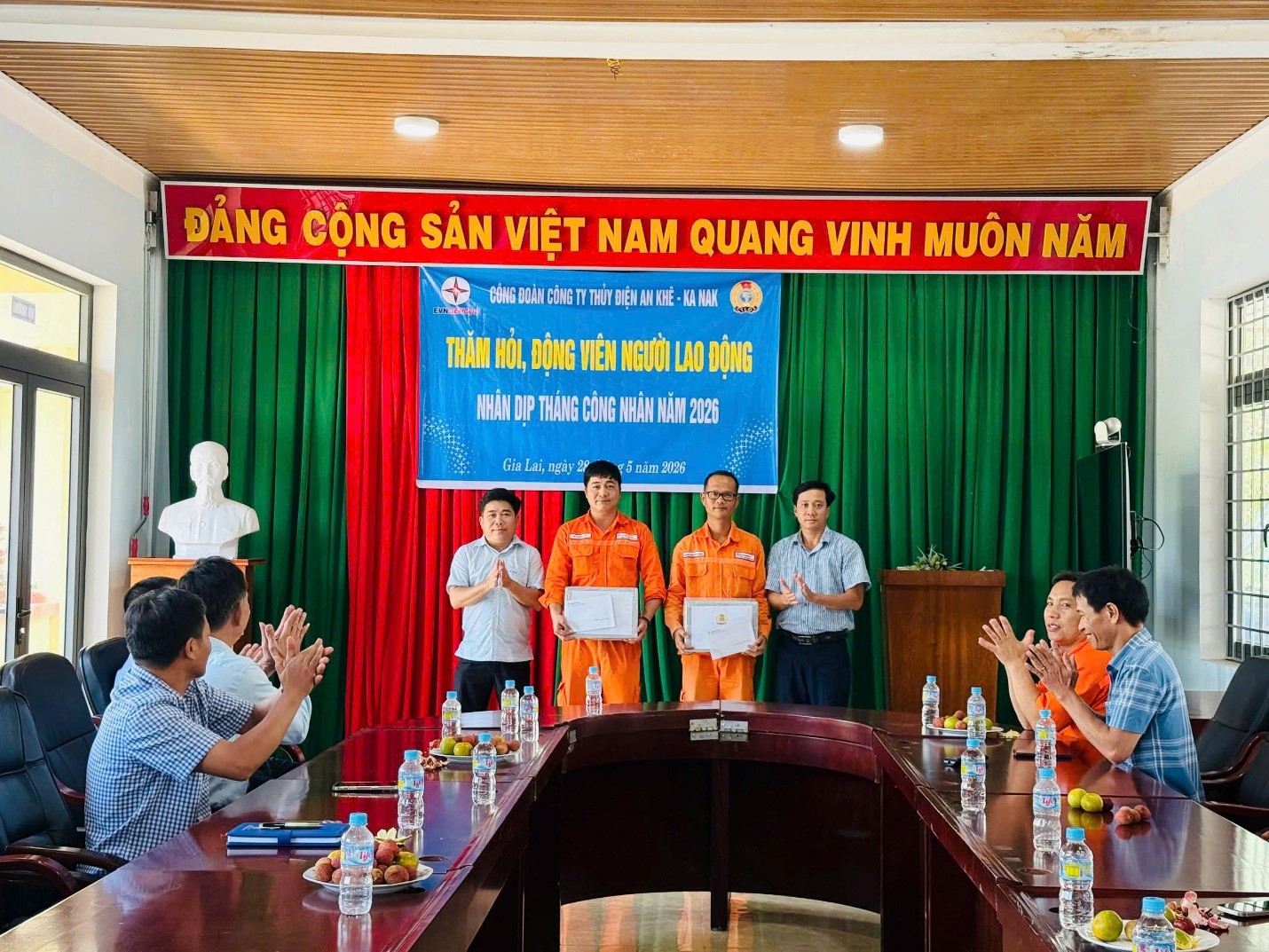 The image shows a gathering of officials and dignitaries in Vietnam, likely in a meeting room, with a Vietnamese flag and a large banner promoting Vietnam's national day and a speech.AI-generated content may be incorrect.
